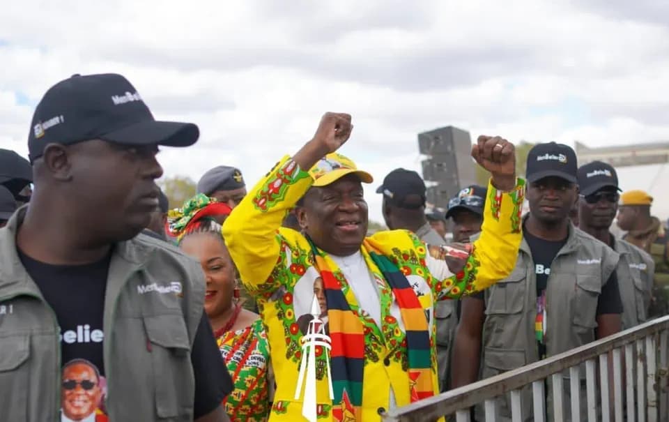 The President raising a fist while greeting supporters at a rally.